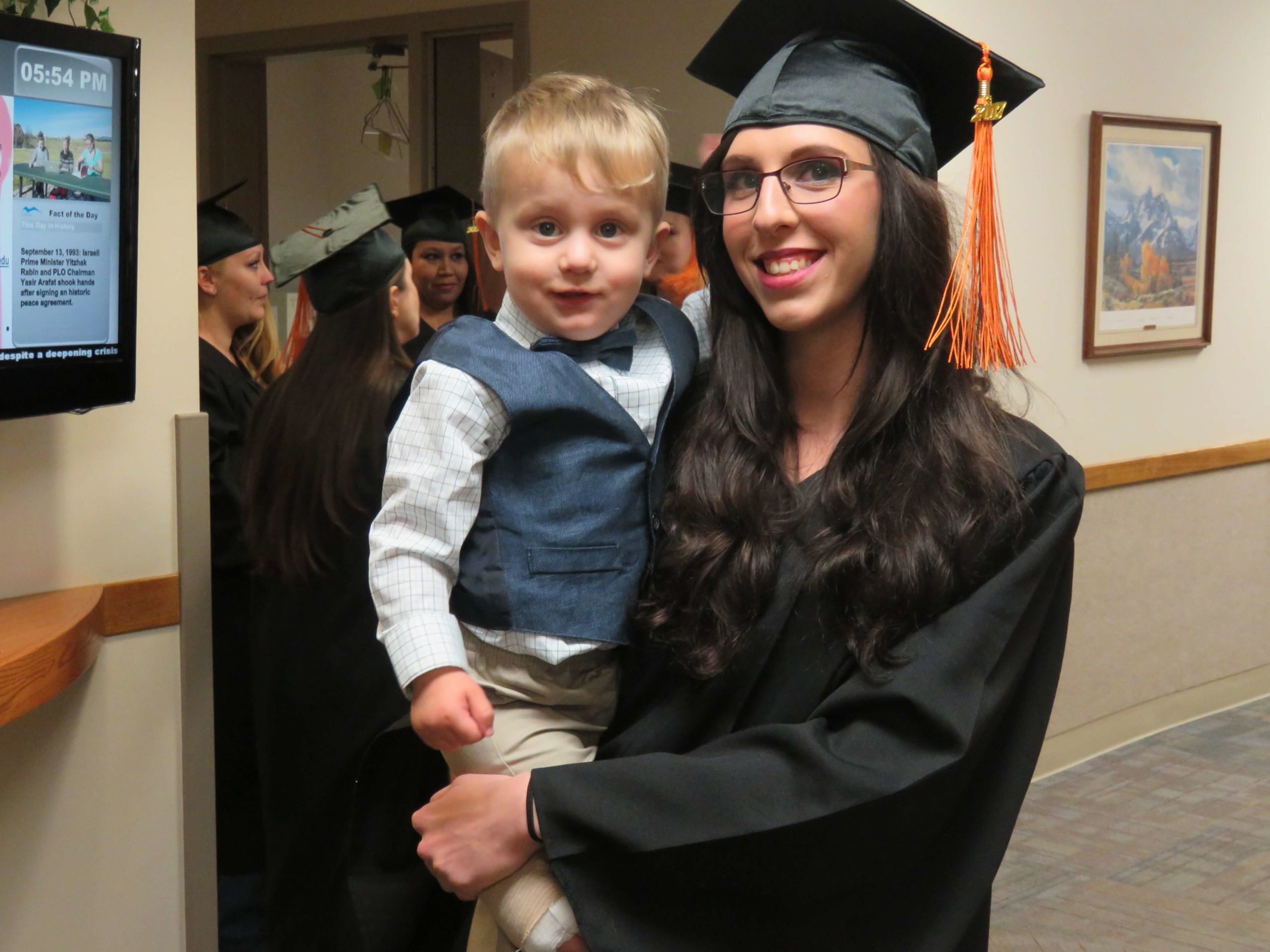 Mom graduates while holding child